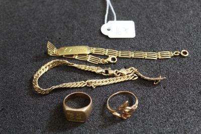 un bracelet en or, une bague et d'autres bijoux posés sur une table