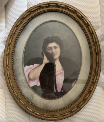 une vieille photo d'une femme en robe rose tenant un chat noir