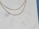 a gold chain necklace on a marble slab