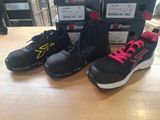 trois paires de chaussures de course noires et roses posées sur une table en bois