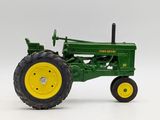a green toy tractor with yellow wheels on a white surface