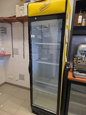 un réfrigérateur qui se trouve dans le coin d'une pièce