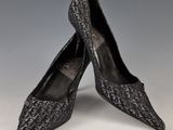 une paire de chaussures en peau de serpent noire posée sur une surface blanche