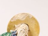 a figurine of a man with a hat on his head