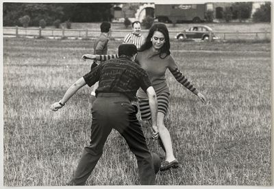 photographie en noir et blanc d'un groupe de personnes jouant au frisbee