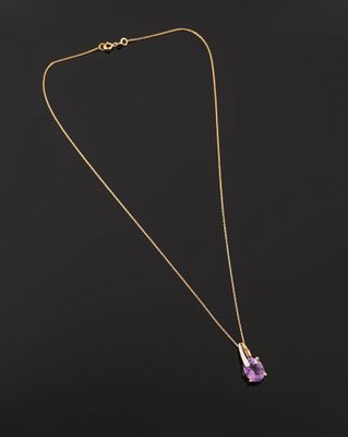 un collier en or avec un pendentif en améthore sur fond noir