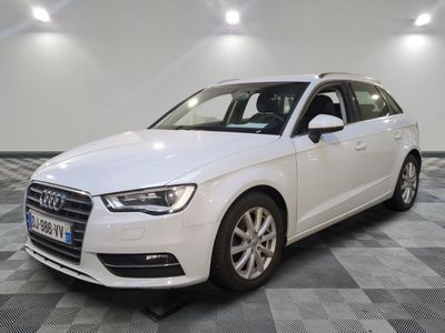 L'Audi blanche est garée dans une grande pièce au sol carrelé en damier.