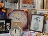 a table with a clock, picture frames, pictures, and other items on it