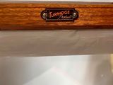 a close up of a wooden table with a name plate on it