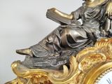 a statue of a woman reading a book on top of a clock