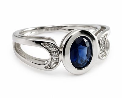 une bague ovale sertie d'un saphir et de diamants, sur fond blanc