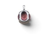 a silver pendant with a red stone inside of it