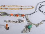 tout un tas de colliers et de bracelets différents posés sur la table
