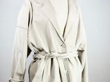 beige trench coat on a mannequin stand on a white background