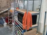 une étagère sur laquelle est posé un micro-ondes, dans un garage