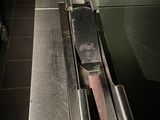 un plan de travail en acier inoxydable sur lequel est posé un couteau, dans une cuisine professionnelle
