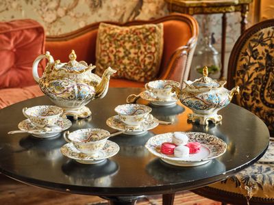 une table sur laquelle sont disposées de nombreuses tasses à thé et soucoupes
