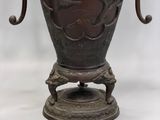 a vase that has a bird on it on a stand