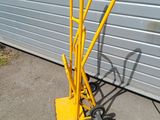 a yellow hand truck that is parked next to a garage door