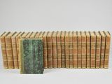 several old books stacked on top of each other on a white surface
