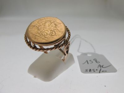 une image représentant une bague sur laquelle repose une pièce d'or