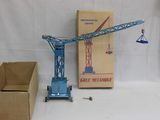 une grue bleue posée à côté d'une boîte et d'un carton