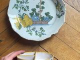a person holding a bowl and a plate on the floor