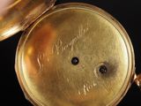 a close up of a gold pocket watch on a black background