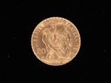 a close up of a gold coin on a black surface