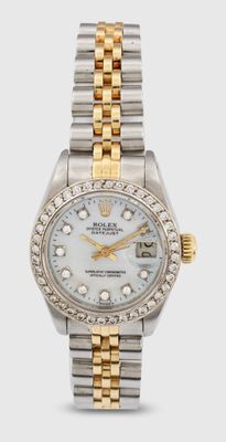 un gros plan d'une montre posée sur une surface blanche, sertie de diamants