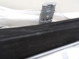a black bag sitting on top of a bed next to a laptop computer