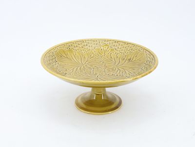 brass footed bowl with a floral design on a pedestal