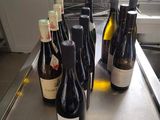 several bottles of wine are lined up on a counter in a kitchen