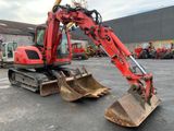 a red excavator that is sitting in a parking lot