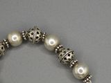 un gros plan sur un bracelet orné de perles et d'une croix