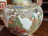 a large vase with a peacock on it on a table