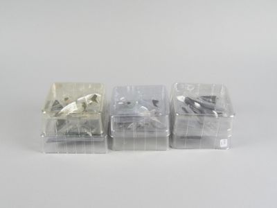 trois morceaux de plastique sont posés sur une surface blanche