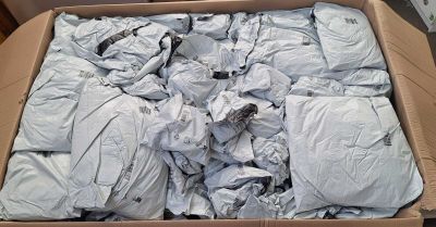 a cardboard box filled with white shirts and white sheets
