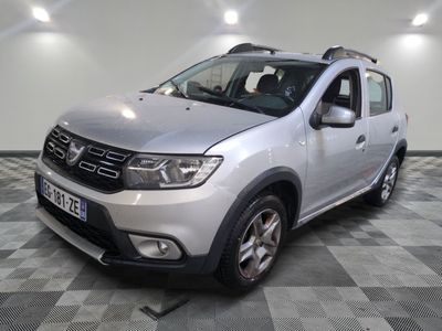 une photo d'une Dacia argentée garée sur un sol à damier