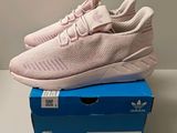 a pair of pink sneakers sitting on top of a blue box