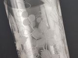 someone is holding a glass with a design on it