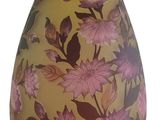 a yellow vase with pink flowers on it on a white background