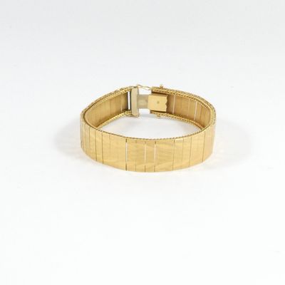 une image d'un gros plan d'un bracelet en or sur un fond blanc