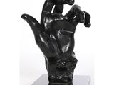 sculpture représentant une main tenant un oiseau, posée sur un socle en marbre noir
