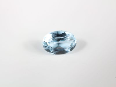 un gros plan d'une topaze bleue posée sur une surface blanche