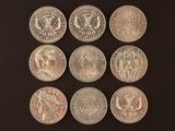 six different types of silver coins on a black surface