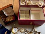 a red case with a bunch of jewelry inside of it