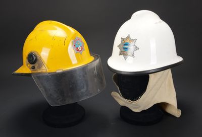 deux casques de chantier jaunes et blancs posés l'un sur l'autre