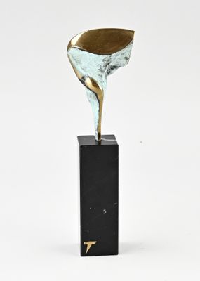 une sculpture en bronze représentant une fleur, posée sur un socle en marbre noir