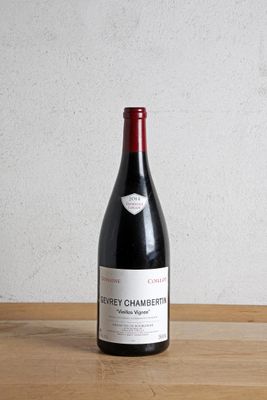 la bouteille de vin rouge est posée sur une table en bois